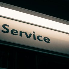A lit sign with the word service on it